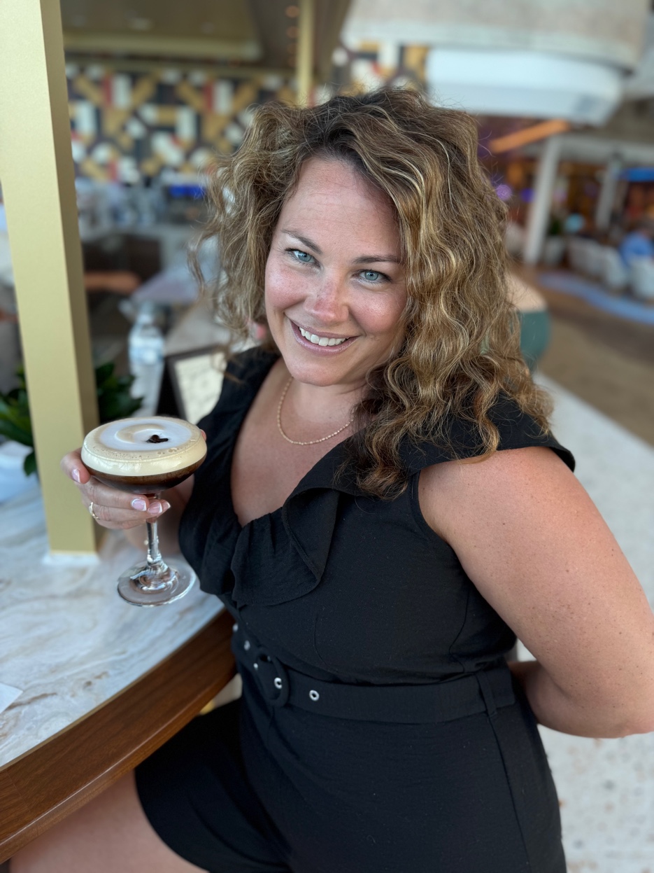 Kimberly, founder of Slice of Life Travel, enjoying a cocktail at a resort